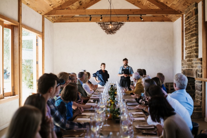 Group of people seated at a long table listening to restaurateur speak at a Tasting Australia event in Barossa, South Australia © South Australian Tourism Commission